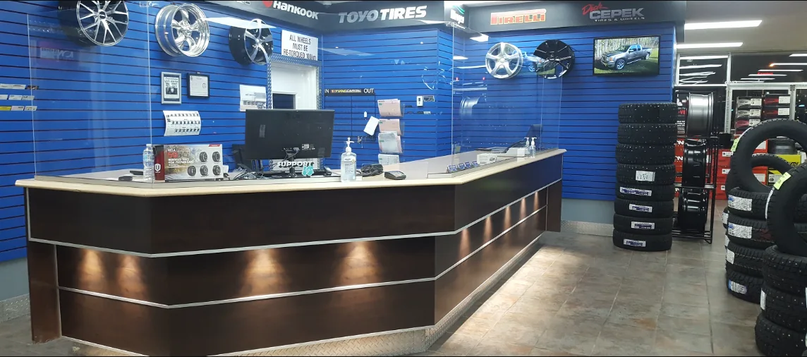 The sales counter inside Tire Capital, with wheels on the wall and tires stacked on the floor